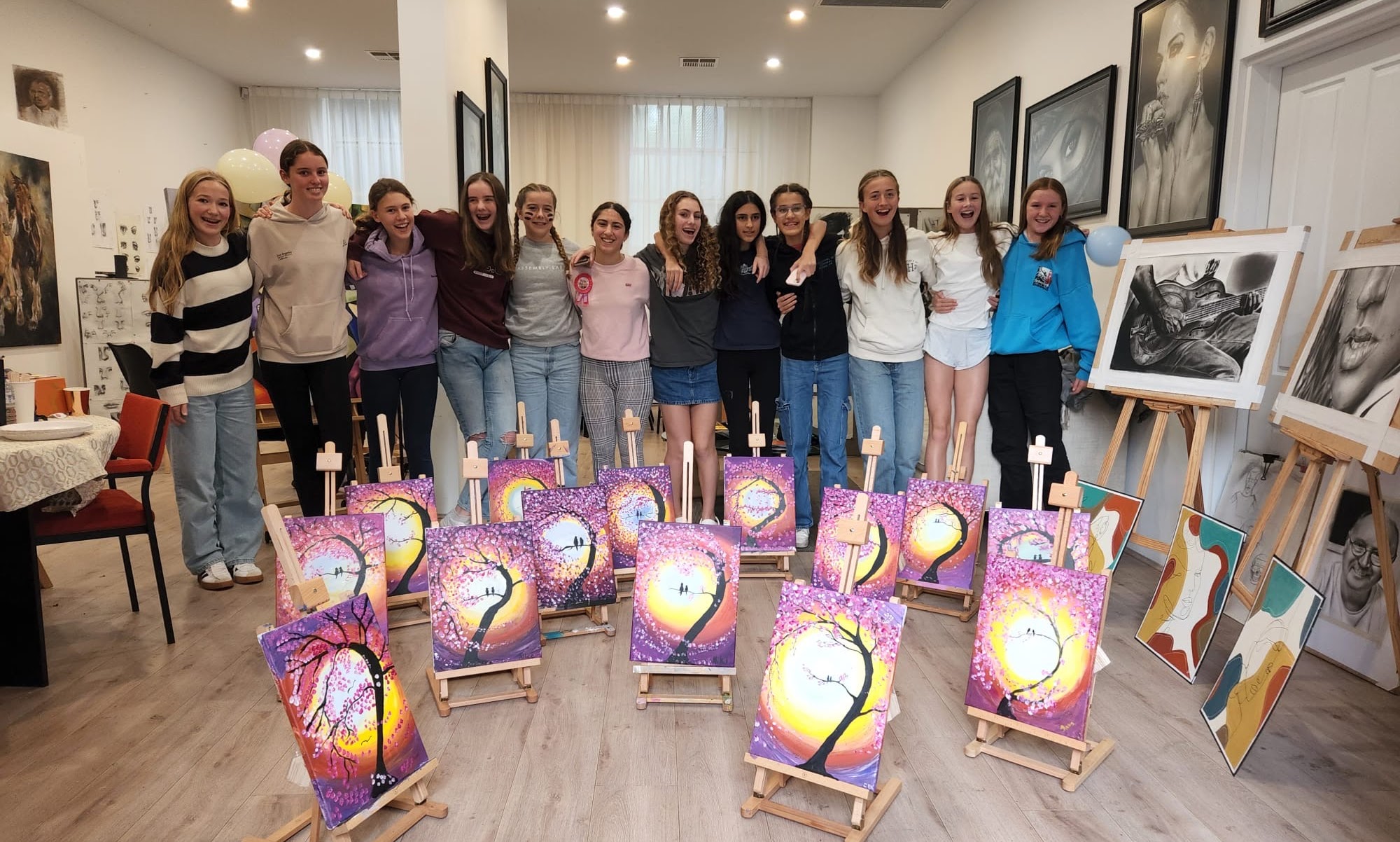 Young students with the galaxy paintings they made together